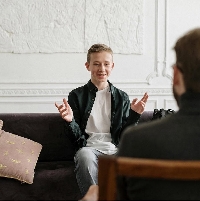 A kid smiling and gesturing during a counselling session