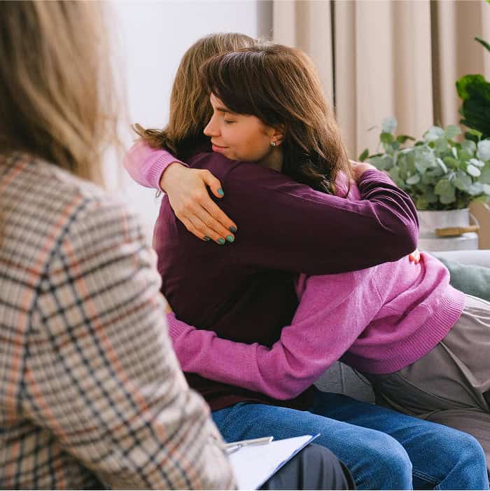 Two people hugging during their session with a counsellor