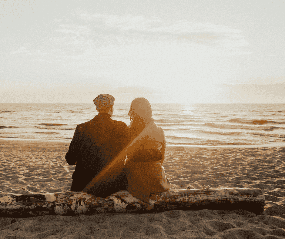 Couple leaning side by side on a beach